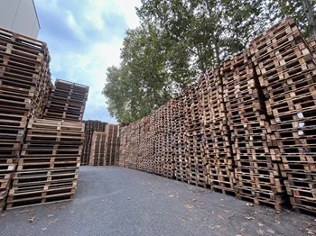 Palets de madera usados apilados en exterior para venta directa en Cataluña